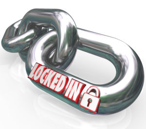 Locked In words on metal chain links to illustrate a commitment or contractual obligation